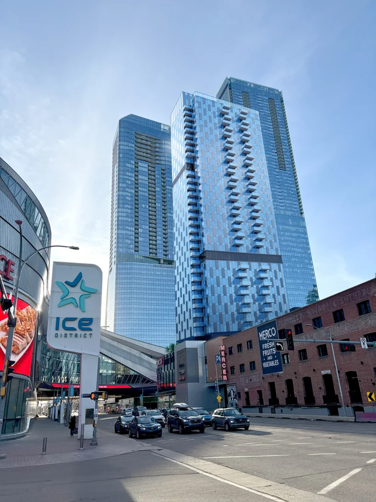 Connect Centre building shown from street level with high-rise towers and city traffic nearby.